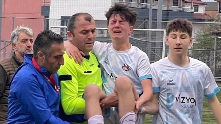 YÜRÜMEKTE ZORLANAN FUTBOLCUYU KUCAĞINA ALIP SAHA DIŞINA ÇIKARAN HAKEMİN DAVRANIŞI TAKDİR TOPLADI.